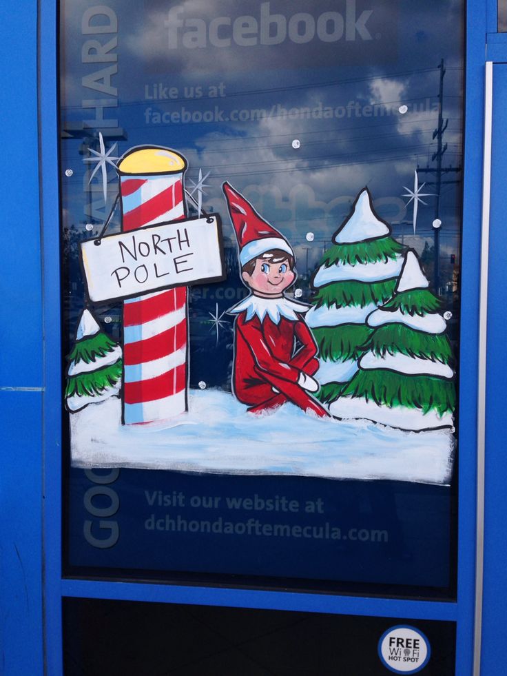 an advertisement on the side of a street sign for north pole, with a elf sitting in front of it