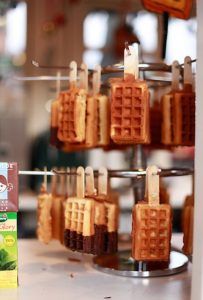 some waffles are hanging from a rack with toothpicks attached to them