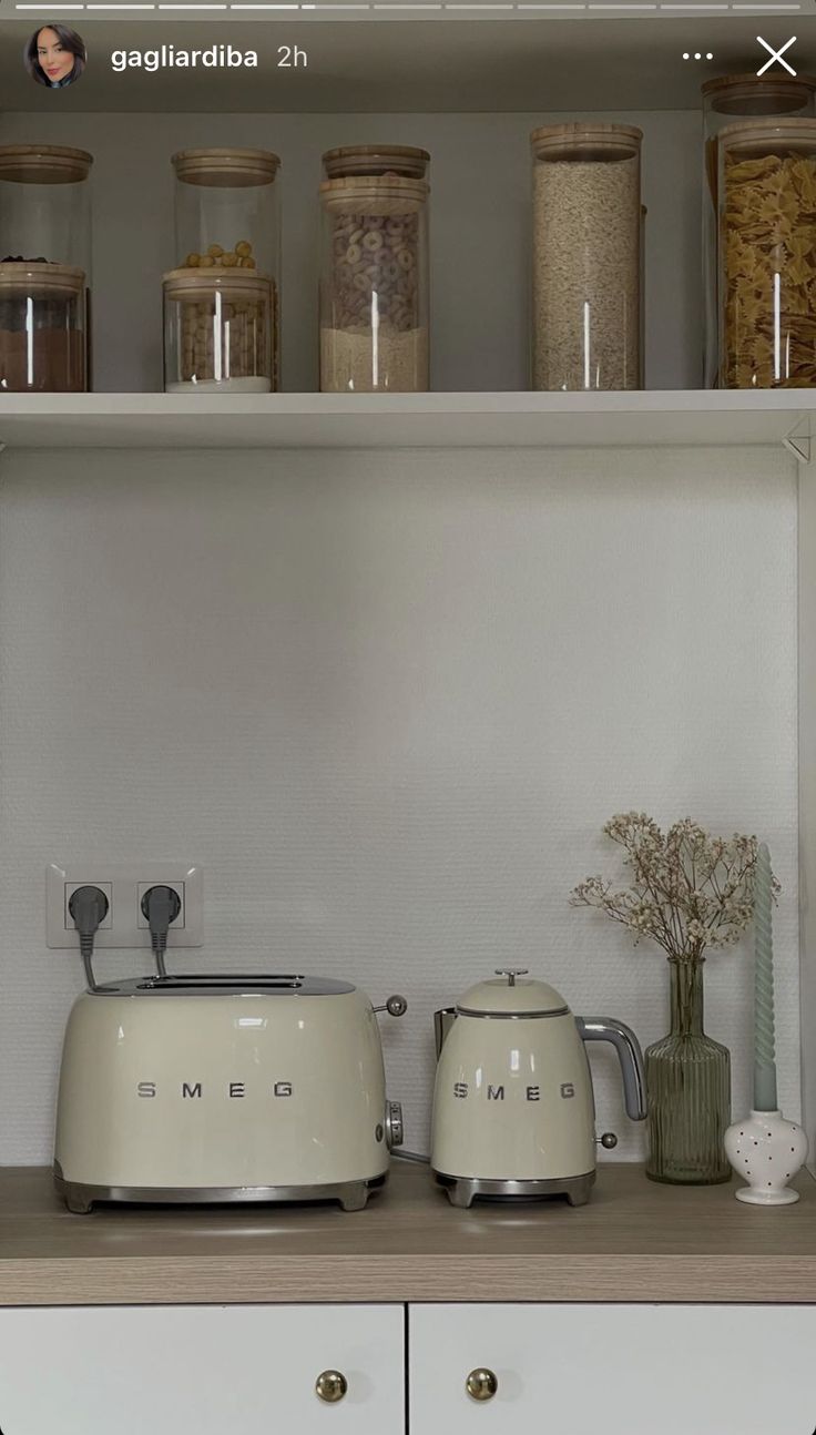 two toasters sitting on top of a counter next to some jars and vases