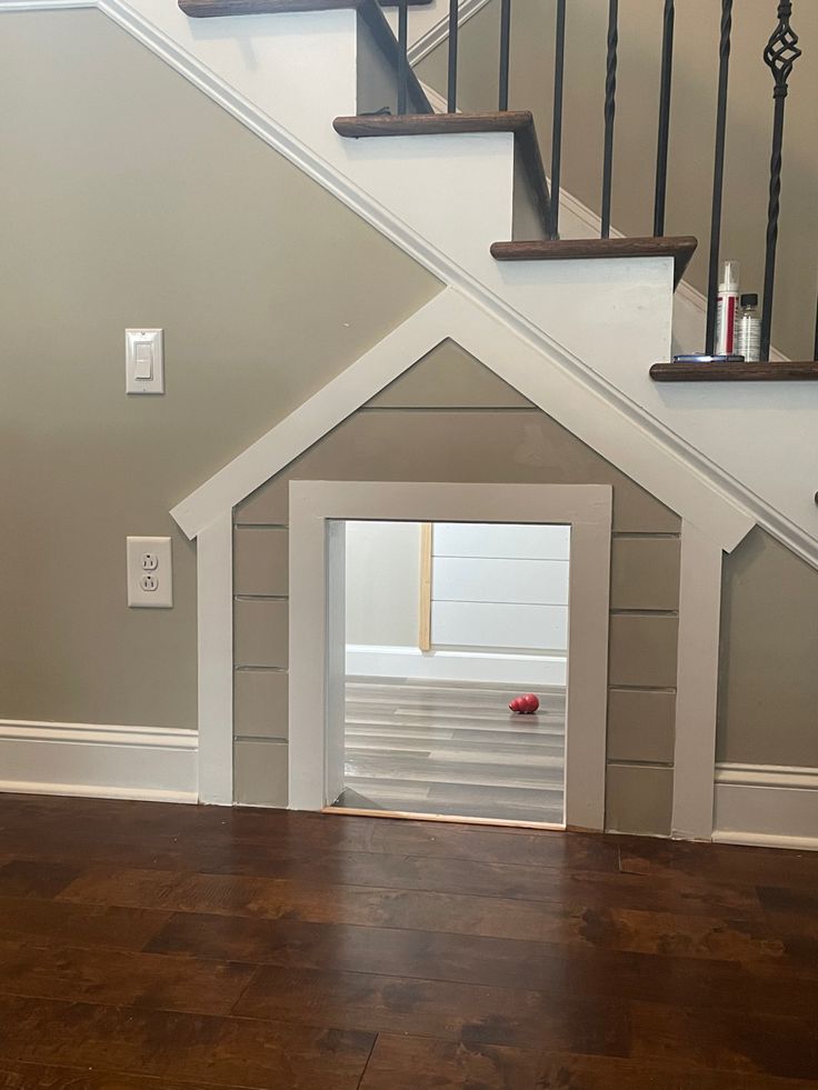 a dog house under the stairs with its door open