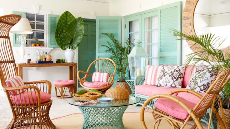 a living room with wicker furniture and green shutters