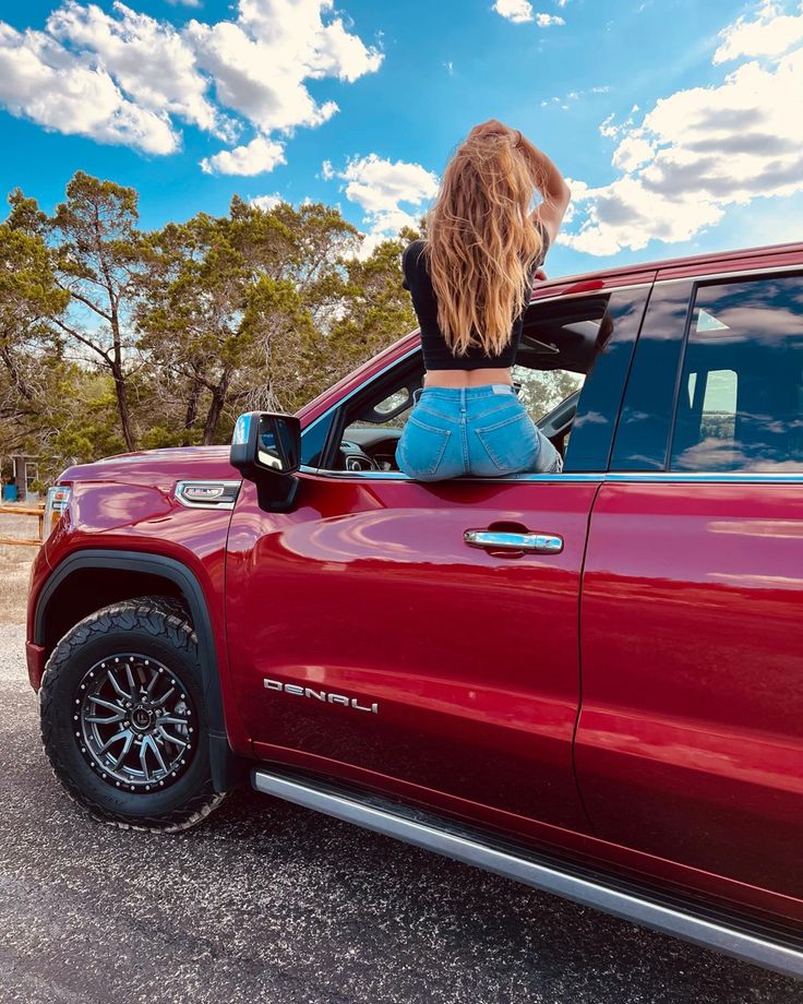 a woman sitting in the back of a red truck