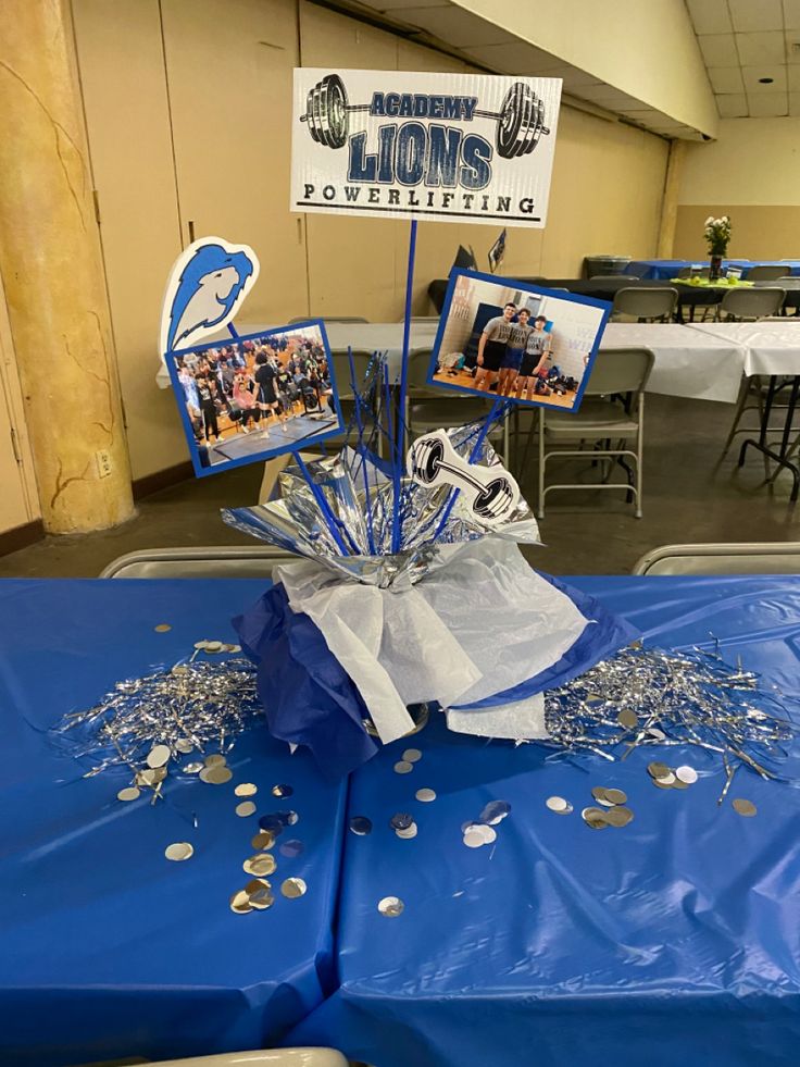 the table is covered with blue plastic and silver confetti for lions day celebration