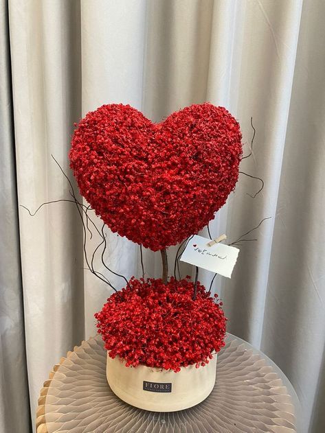 two heart shaped vases on top of each other with red flowers in the middle