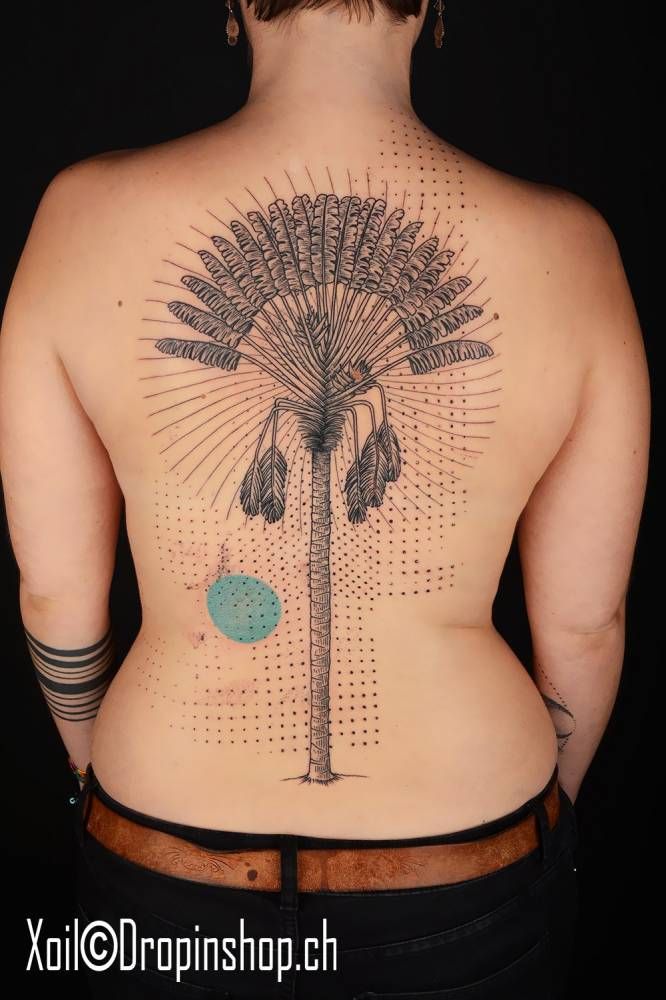 the back of a woman's body with tattoos on it