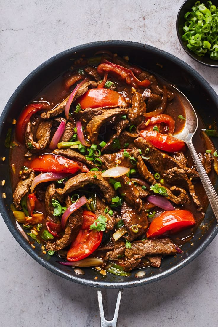 a skillet filled with meat and vegetables