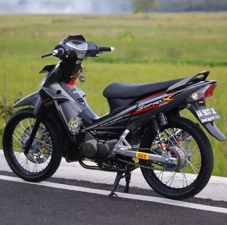 a motorcycle is parked on the side of the road in front of some green grass