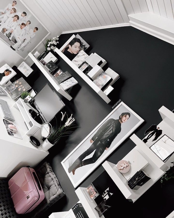 a black and white room with pictures on the wall, luggage and other things in it