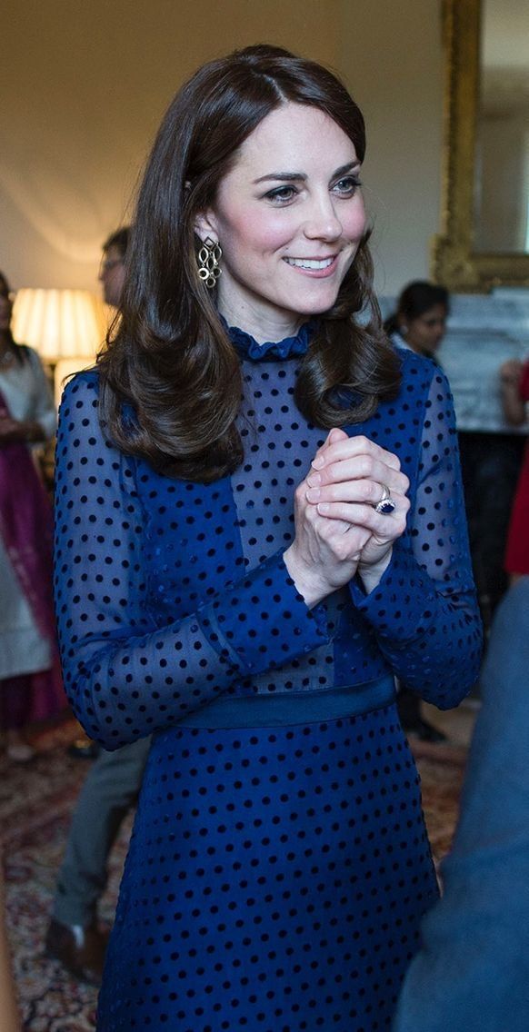 the duke smiles as he stands in front of other people