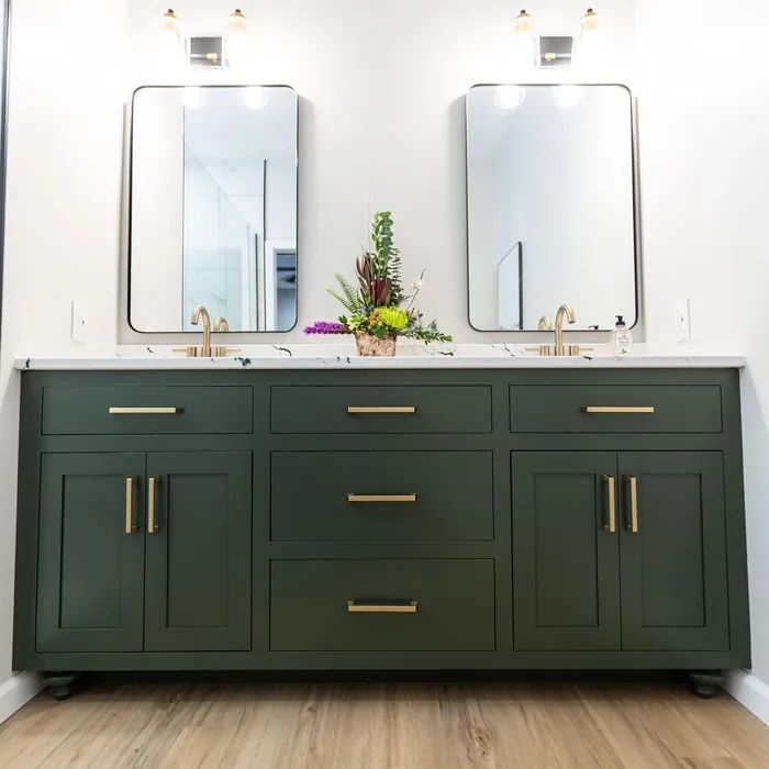 a bathroom with two sinks and mirrors on top of the countertop, in front of a white wall