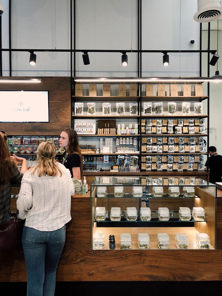 two women are standing in front of the counter at a cosmetics store, talking to each other