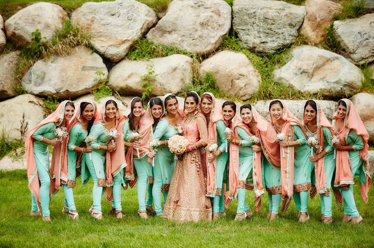 a group of women standing next to each other on top of a lush green field