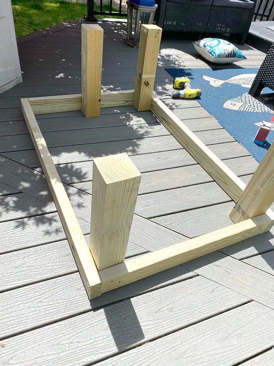 a wooden bed frame sitting on top of a wooden floor next to a blue rug