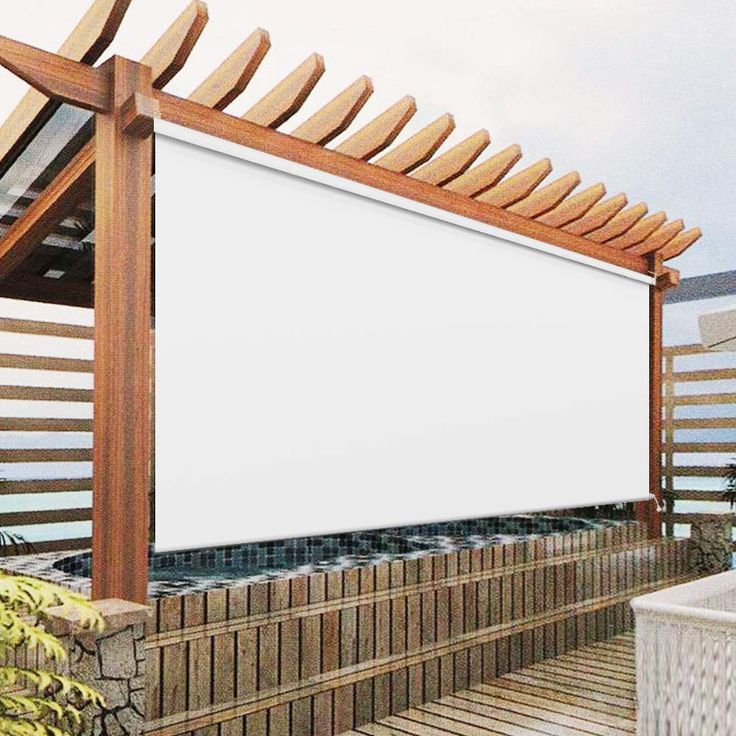 a large white screen on the side of a wooden structure next to a planter