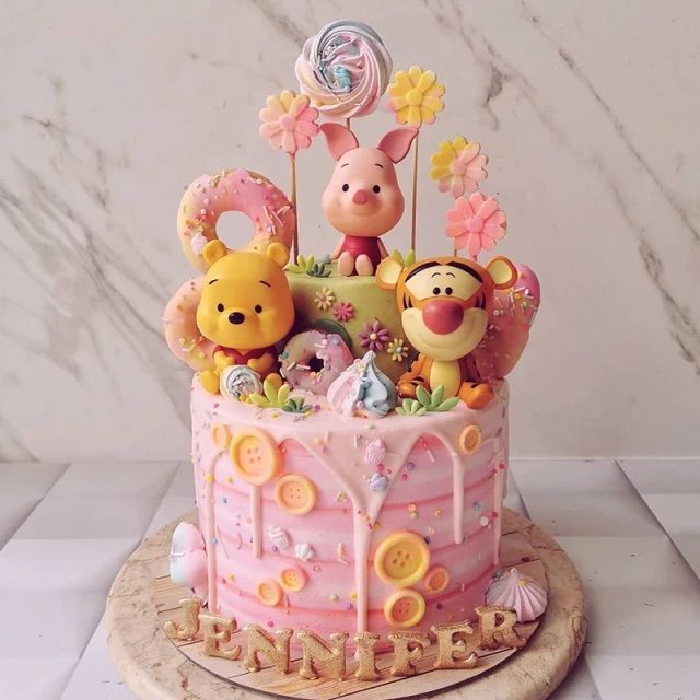 a winnie the pooh birthday cake is decorated with fondant and candies as decorations