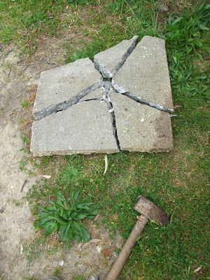 a broken concrete block with a hammer on the ground