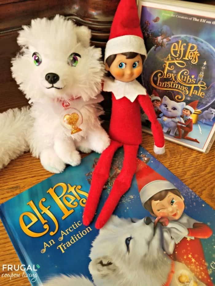 two stuffed animals and an elf are sitting on the table next to some children's books