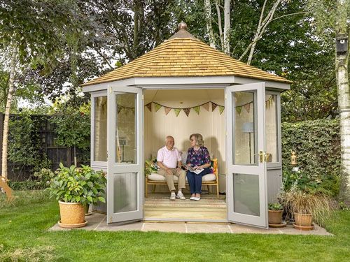 two people sitting in a small wooden gazebo