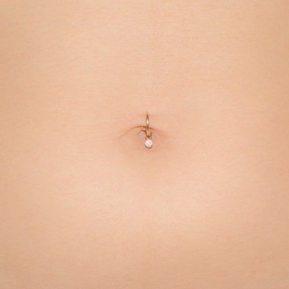 a woman's stomach with a tiny white bead in the middle of it