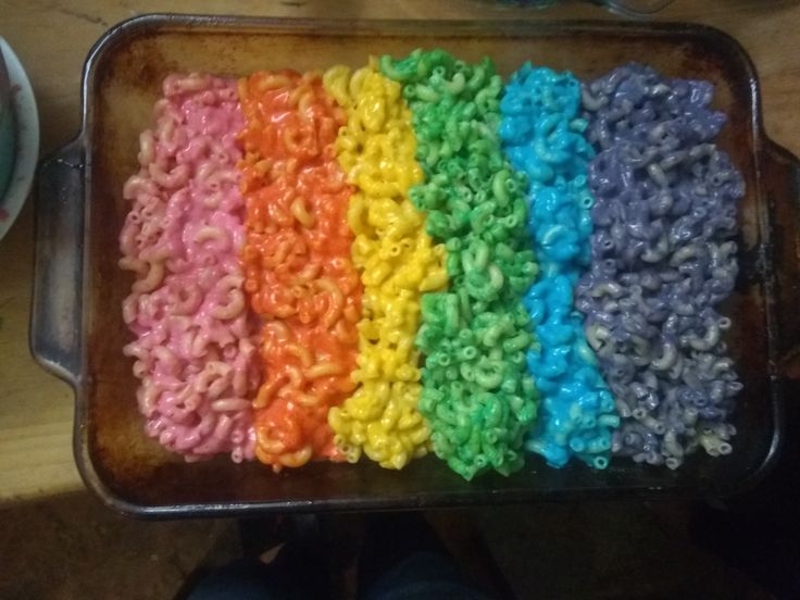 a pan filled with rainbow colored rice krispy kreme cereals on top of a wooden table