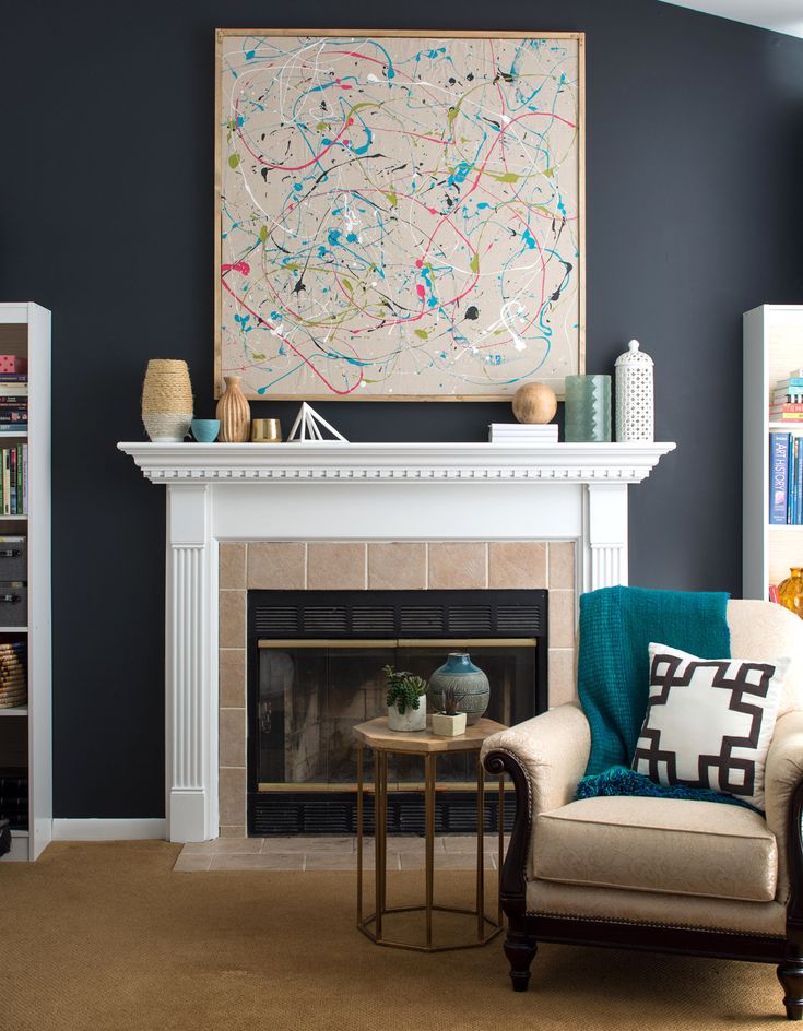 a living room filled with furniture and a painting on the wall above a fire place