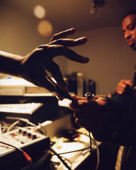 two hands reaching out towards each other in front of sound equipment