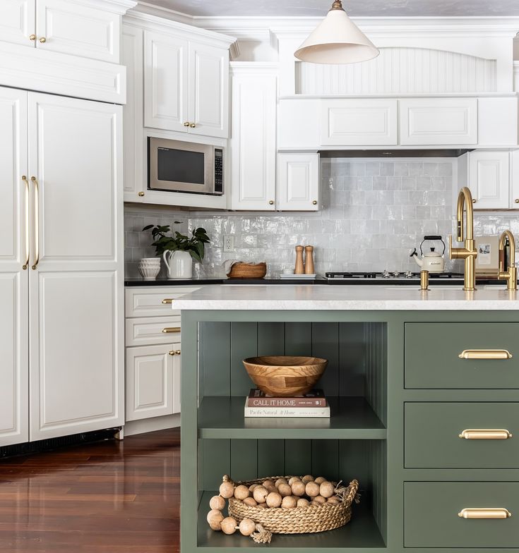 a kitchen with white cabinets and green island