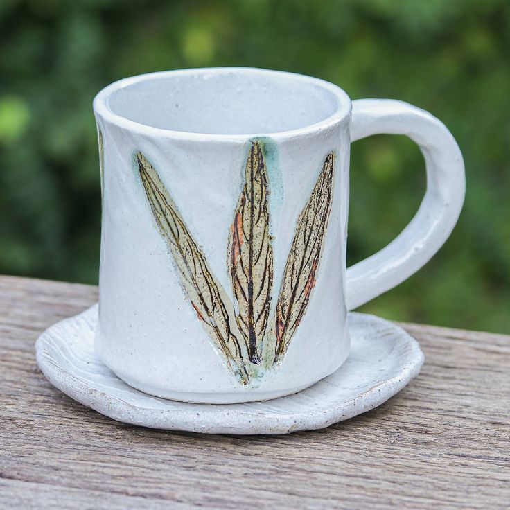 a white coffee cup sitting on top of a wooden table