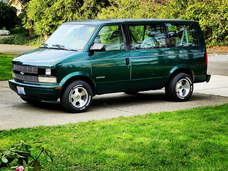 a green van is parked on the sidewalk