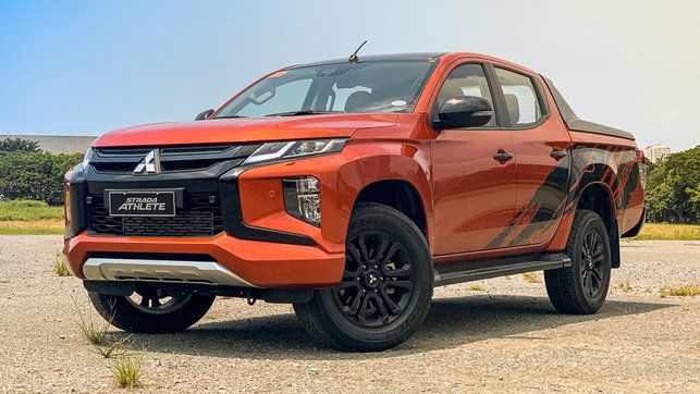 a red pick up truck parked on top of a dirt field