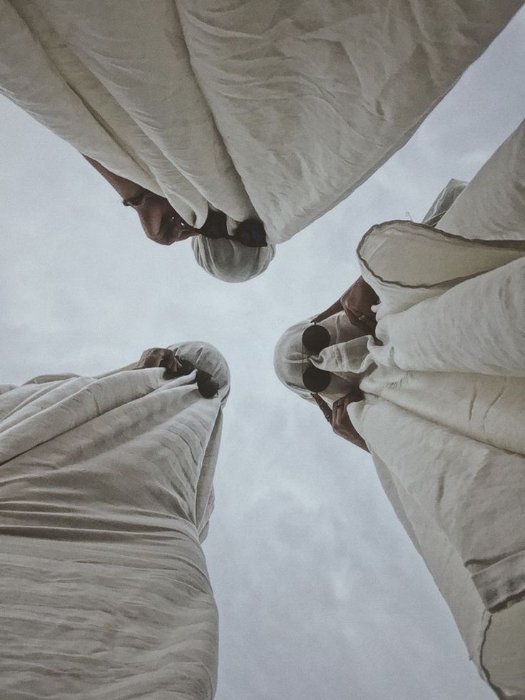 looking up at the top of two umbrellas with people standing under them and covering their faces