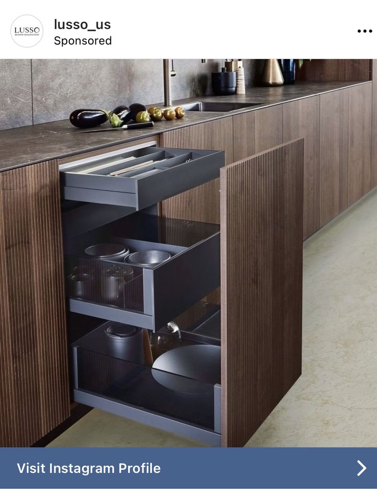 an open cabinet in the middle of a kitchen with pots and pans on it