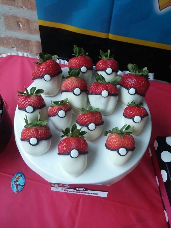 there are many strawberries in the shape of pokeballs on this cake plate