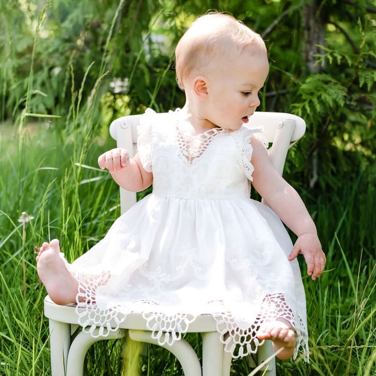 Handmade in the USA A delicately detailed cotton lace with a scalloped edge layered to create a simply elegant look for her special day! Lightly ruffled lace sleeves are a perfect touch to the lace bodice. Pair with her matching Lily accessories to complete her look. 100% light ivory cotton lace Light ivory edge lace Ivory silk ribbon Garden Party Lace Dress With Ruffles, Ruffled Lace Dress For Garden Party, Garden Party Ruffled Lace Dress, Spring Cotton Dress With Scalloped Lace, Fitted Lace Dress With Scalloped Edges For Wedding, Spring Baptism Dress With Lace Sleeves, White Ruffled Lace Dress, Fitted White Lace Dress With Scalloped Edges, White Cotton Dress With Scalloped Lace