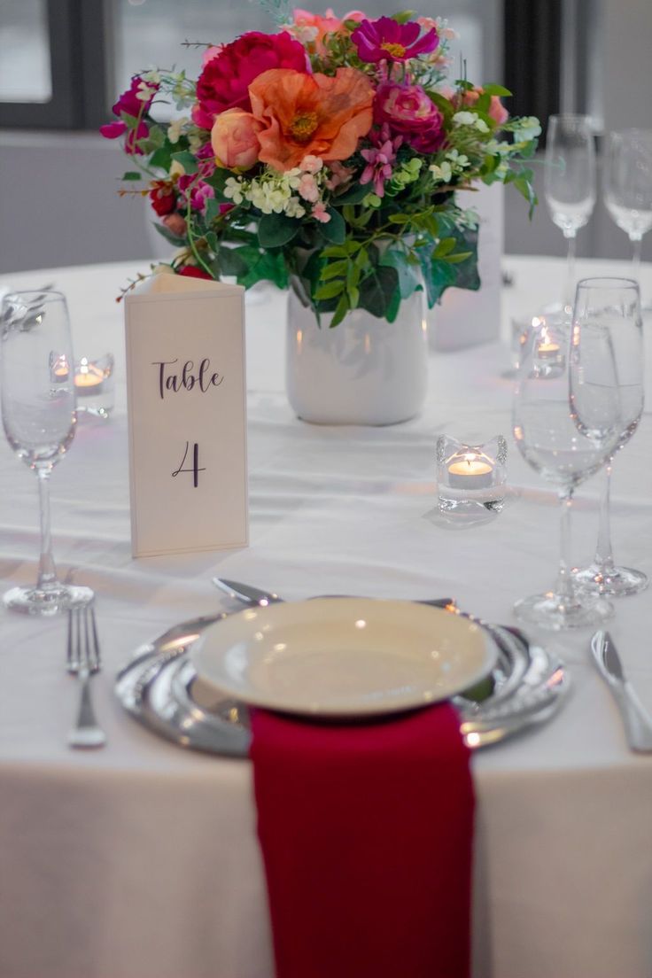 the table is set with place cards and wine glasses