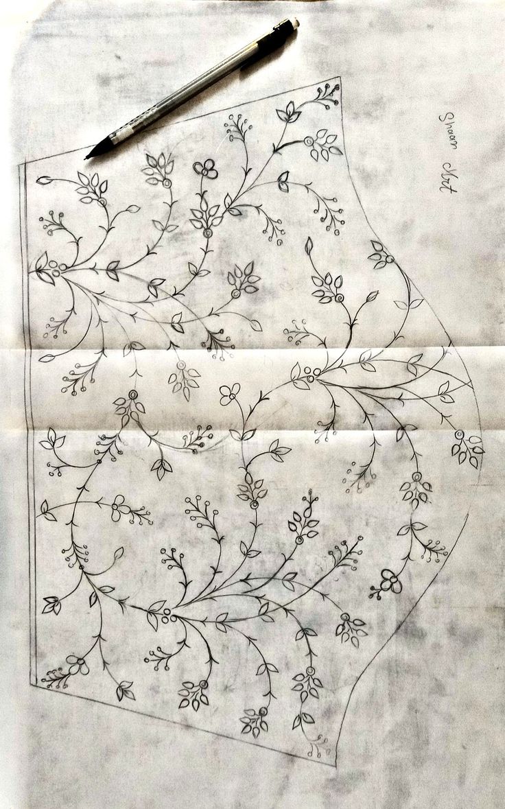 an old piece of paper with flowers on it and a pen next to the pattern