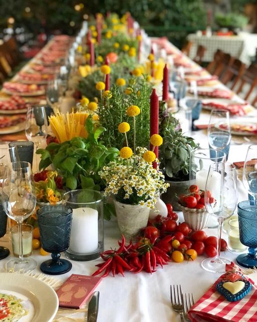 a long table is set with flowers and candles for an outdoor dinner party or gathering