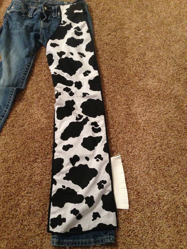 a cow print tie is laying on the floor next to a pair of blue jeans