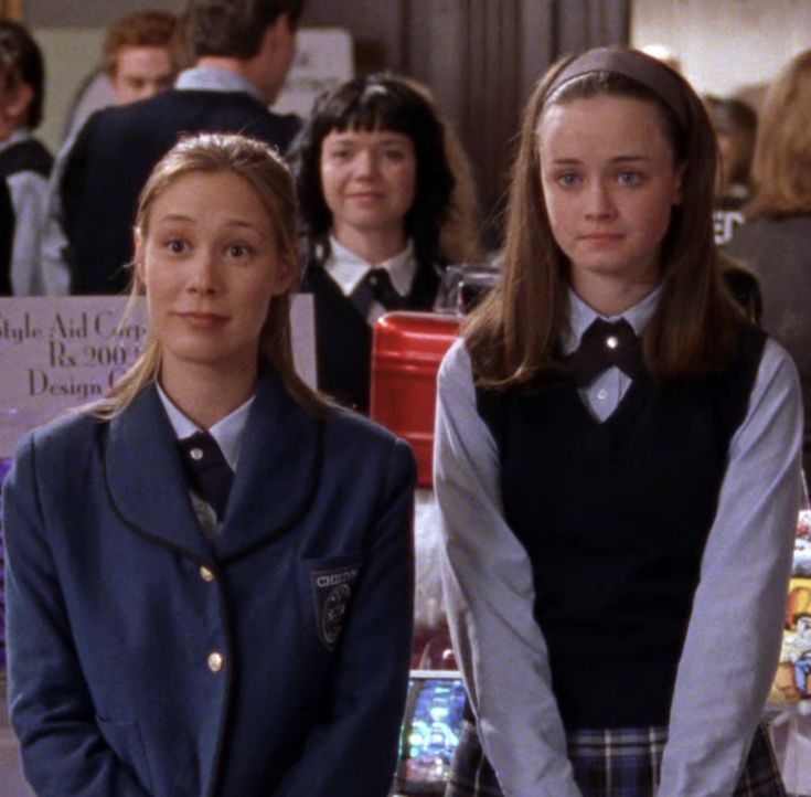 two girls in school uniforms standing next to each other