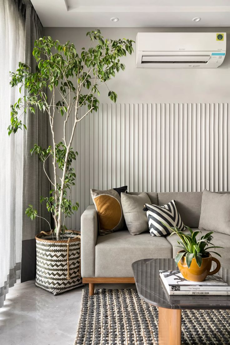 a living room with a couch, coffee table and air conditioner in the corner