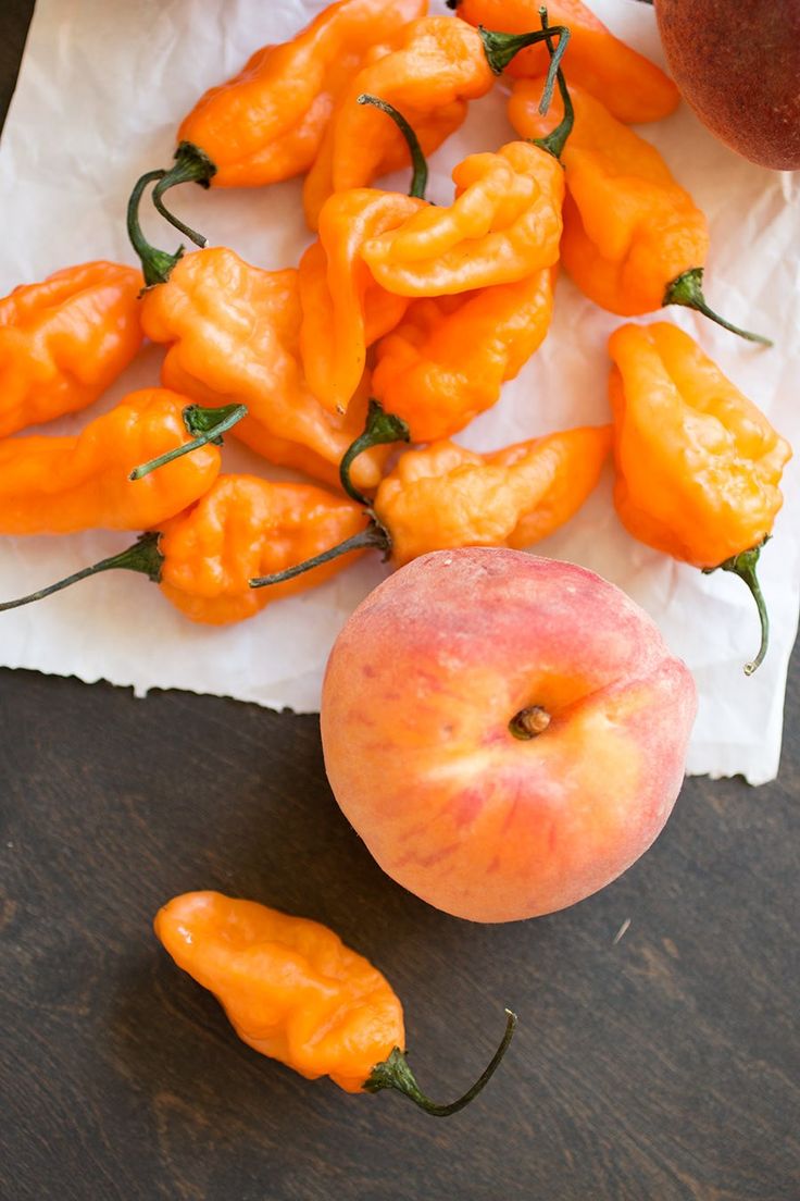 peaches and oranges are sitting on a napkin next to a piece of paper