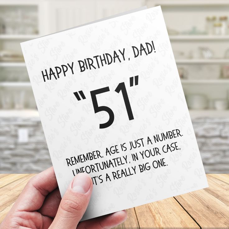 someone holding up a birthday card with the number 51 on it