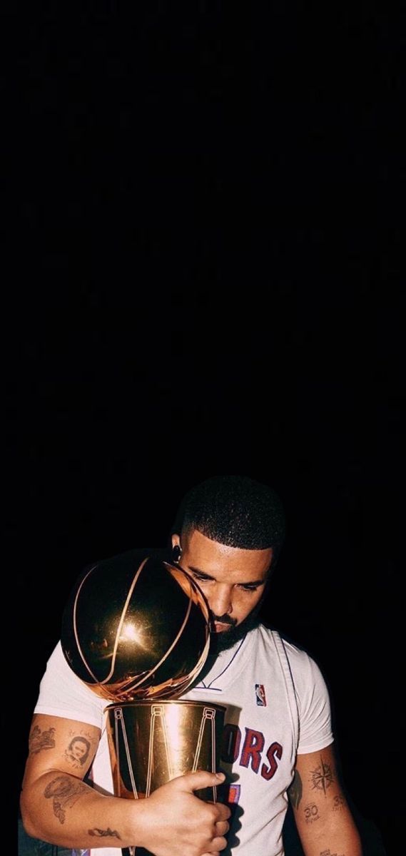 a man holding a basketball trophy in his hands