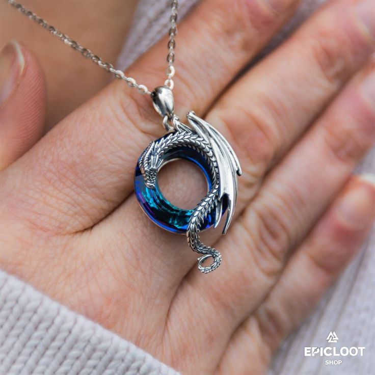 If you love unique and eye-catching jewelry, then you will love our Dragon on Blue Round Crystal Stone 925 Silver Necklace. The centerpiece of this necklace is a beautiful blue crystal stone that is shaped like a round. The crystal is adorned with a detailed dragon design, adding an element of fantasy to the piece. The necklace is perfect for those who want to feel empowered or who need a little extra calm in their life because it does not only bring about peace and tranquility but also brings a Crystal Gemstone Round Pendant Jewelry, Crystal Gemstone Round Pendant Necklace, Crystal Clavicle Chain Necklaces, Crystal Clavicle Chain Necklace With Round Pendant, Crystal Jewelry With Round Stone For Gifts, Round Crystal Gemstone Necklaces, Round Crystal Gemstone Necklace, Turquoise Crystal Jewelry Gift, Turquoise Crystal Jewelry For Gifts