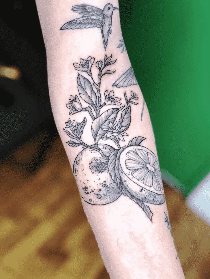 a tattoo on the arm of a person with an apple and humming bird in it