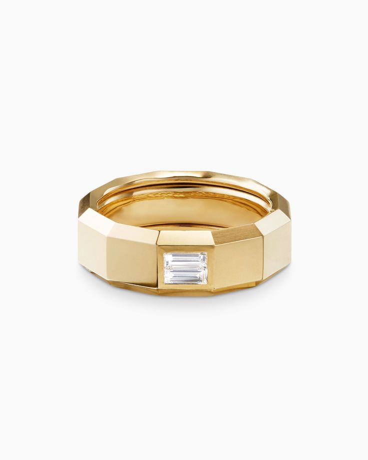 a gold wedding band with a baguette cut in the middle and a diamond on top