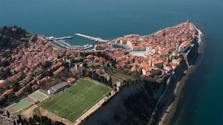 an aerial view of a soccer field in the middle of a large body of water