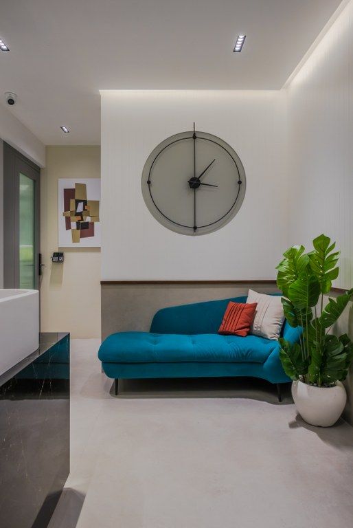 a living room with a blue couch and large clock on the wall