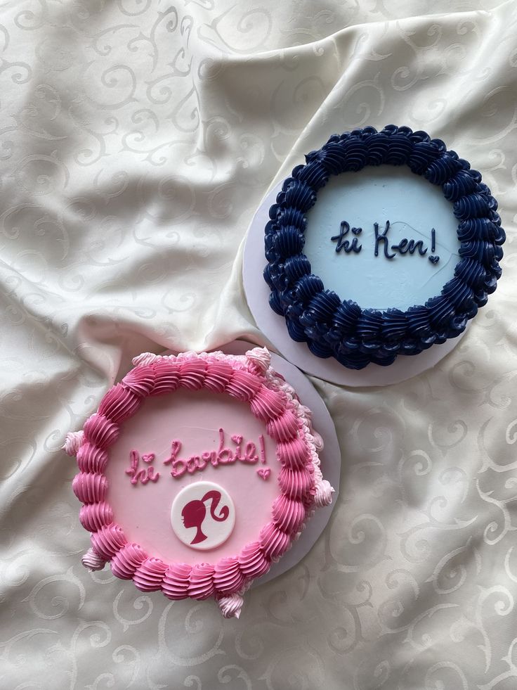 two decorated cakes sitting on top of a bed