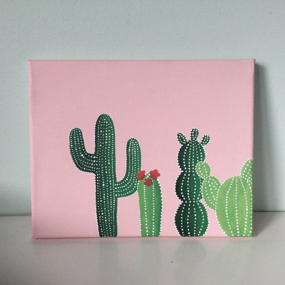 a pink canvas with three green cactuses painted on the front and back, sitting on a table